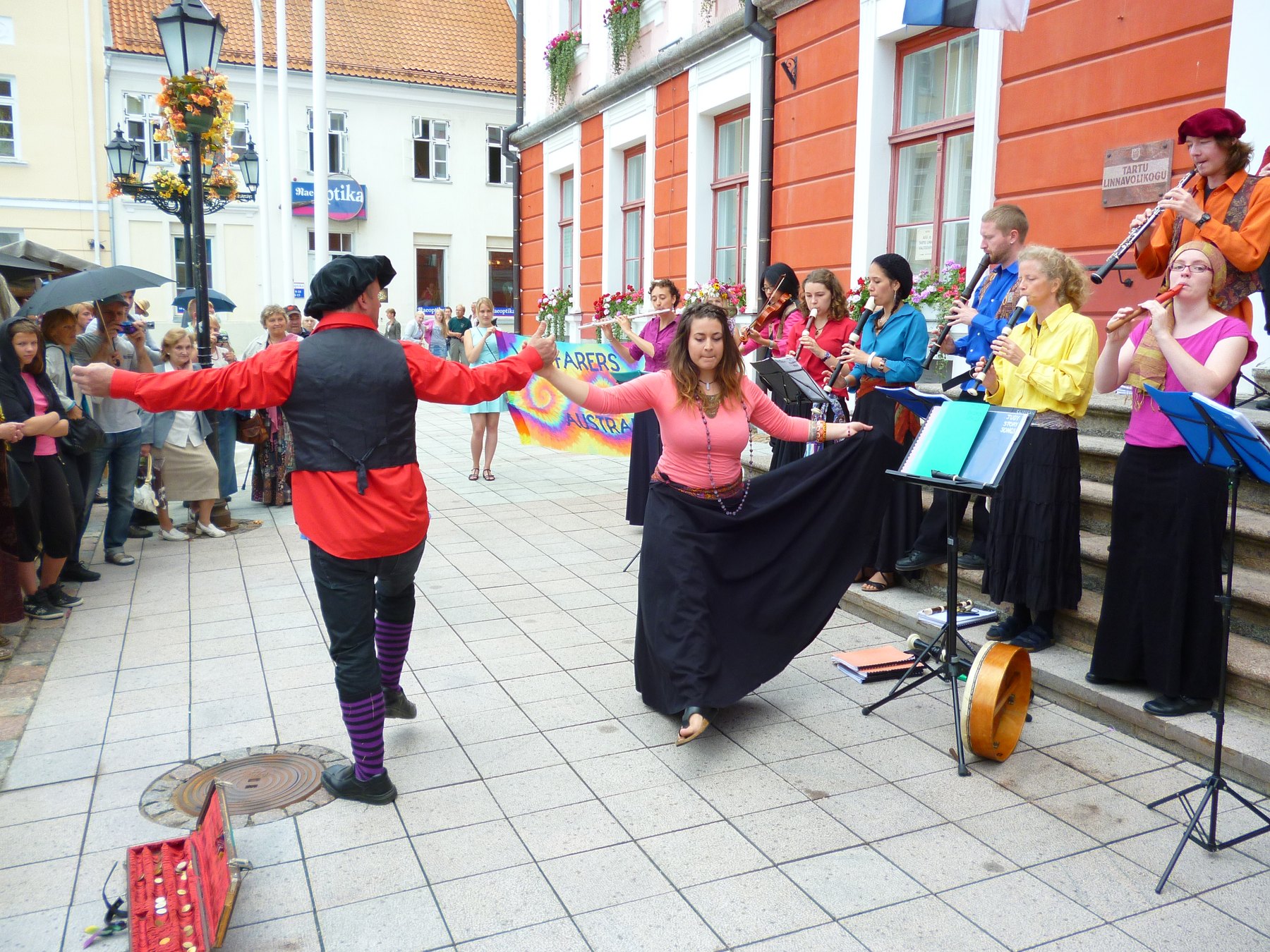 Wayfarers sharing music with a crowd in a town square
